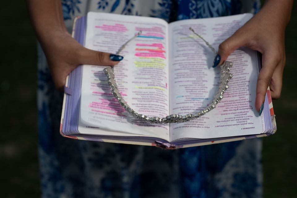 Mãos segurando a Bíblia com a tiara